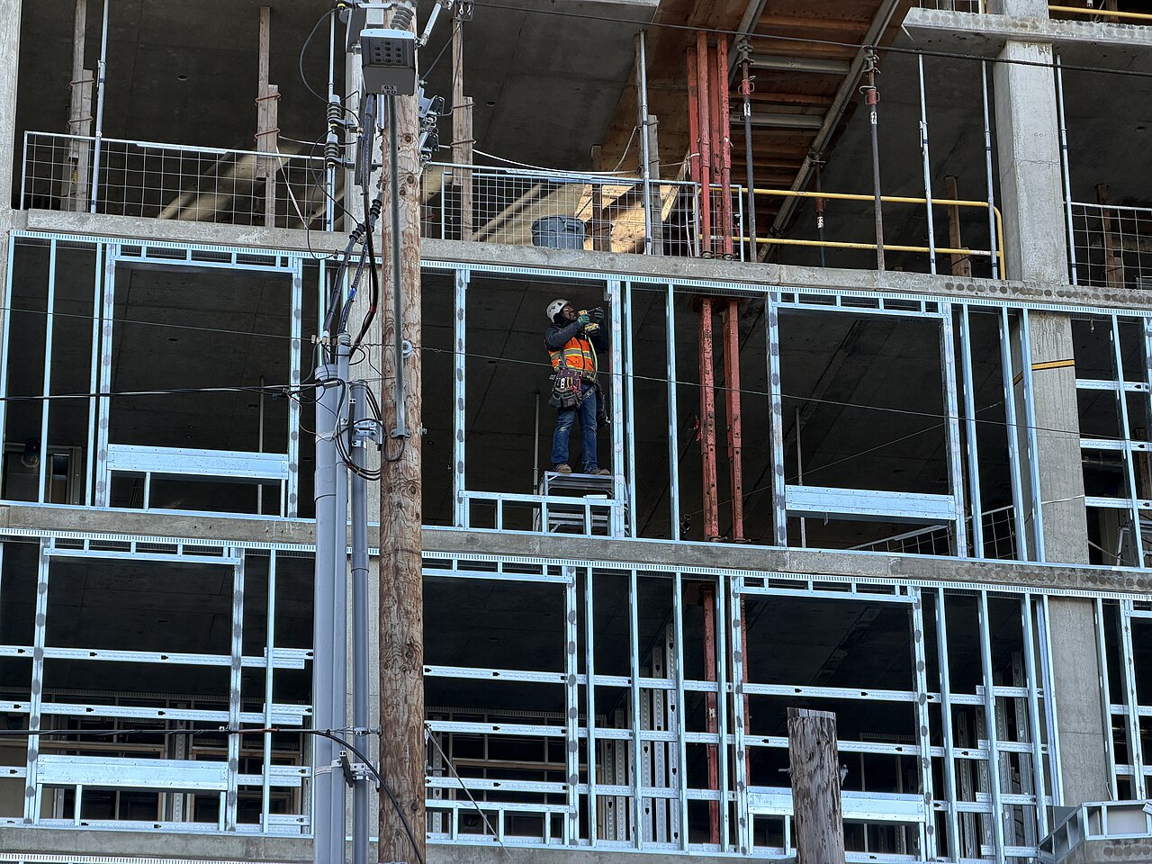 Construction professional on site with hard hat and drawings